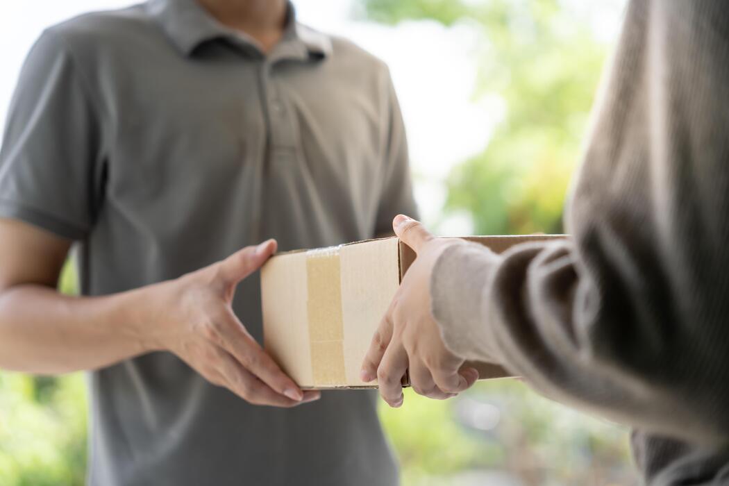 Courier handing an order to a customer